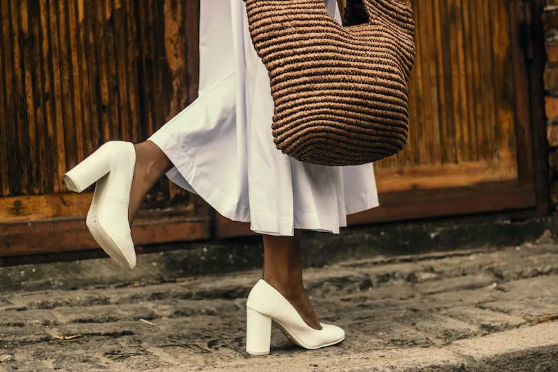 Woman Wearing White Dress and White High-heeled Shoes While Walking on Sidewalk