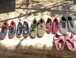 Various footwear for selling placed on stone on street