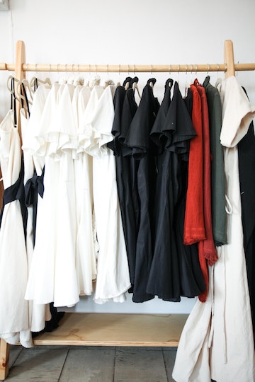 White Black and Red Clothes Hanging on Brown Clothes Rack