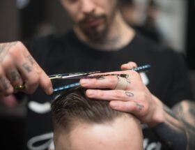 Man Cutting the Hair on the Person Sitting on the Chair