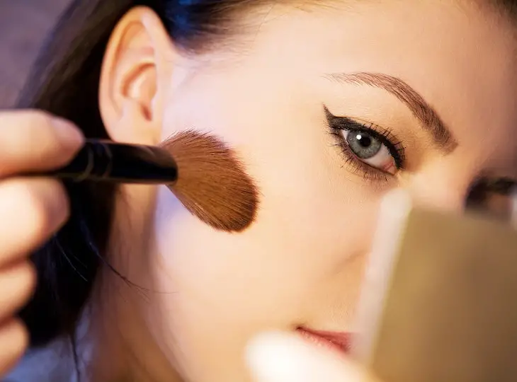 A Woman Using a Makeup Brush
