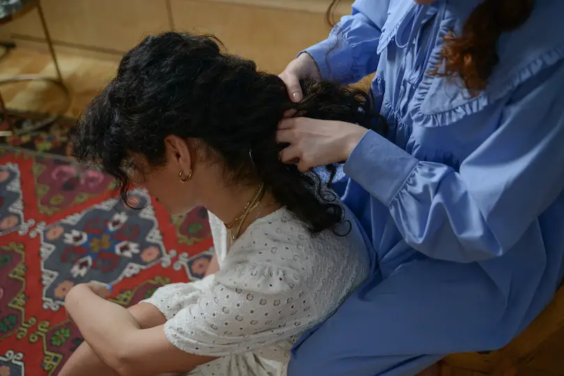 A Woman Braiding Another Woman's Hair