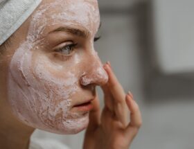Close-up Photo of a Woman Applying Facial Cream