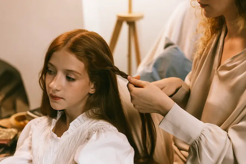 Woman Braiding Teenage Girl Hair